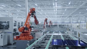 Time-lapse video of Automated Solar Panel Production Line. Orange Industrial Robot Arms Assemble Solar Panel, Placing PV Cells. Modern, Bright Manufacturing Facility.