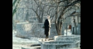 Woman walking through modern architecture in spring. 1980s Kyiv, Ukraine. Amateur, antique video. Autumn city walk. Old family archives, library. Grainy, archival color film. Retro historic archive