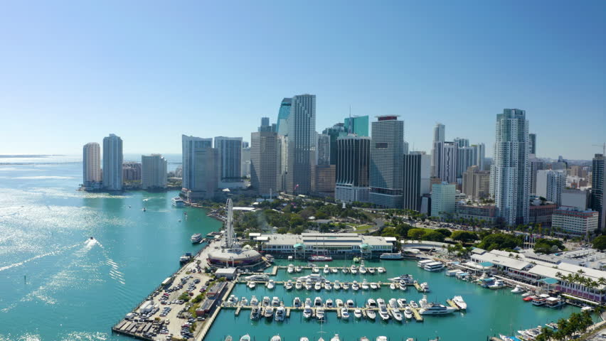 Aerial view of futuristic urban tall buildings and skyscrapers. Multilane road bridge above turquoise water in river. Modern downtown skyscrapers along Miami river. High rise office. Miami. USA. 