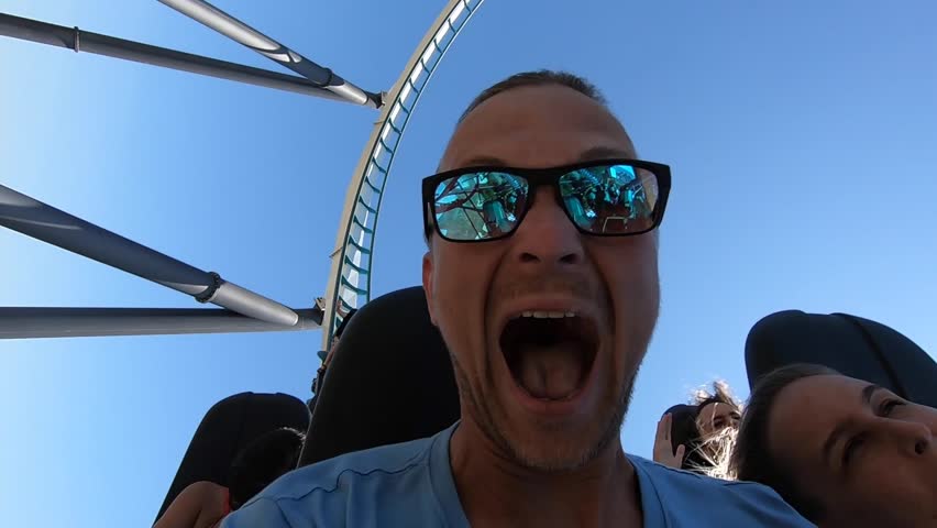 People ride a roller coaster in an amusement park in Spain | Shutterstock HD Video #1099349193