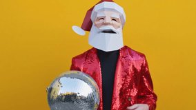 Happy man with funny Santa Claus low poly mask on colored background - Creative conceptual idea for christmas advertising,adult with low-poly origami paper mask doing funny poses