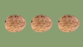 Dried walnuts rotating on green background
