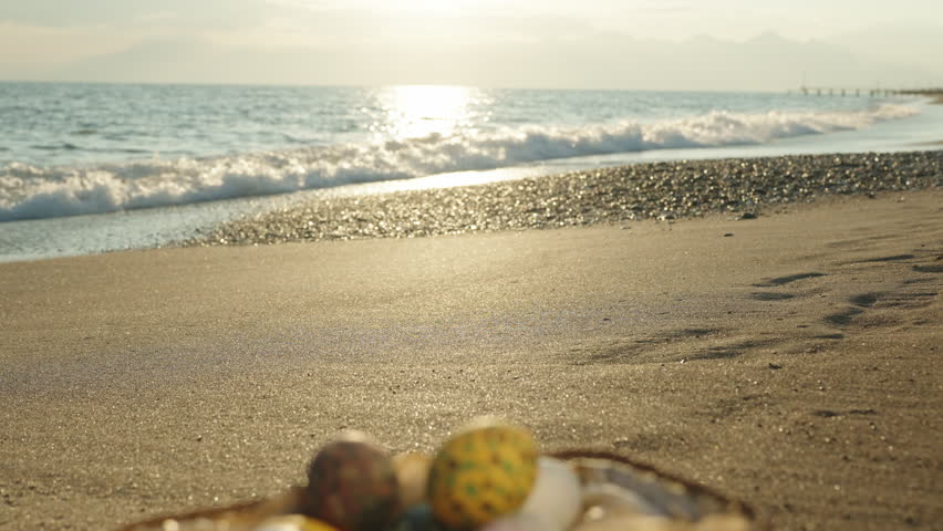 Sunset on the beach by the sea, the focus shifts from the background to the Basket with Easter eggs. Royalty-Free Stock Footage #1099353277