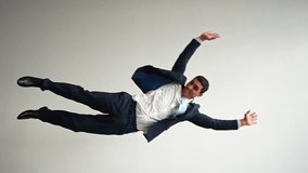 Funny Businessman in a Jacket and Tie Flies and Shouts on a White Background and Falls. Slow Motion. - Powered by Shutterstock - Get 15% off with code: PIKWIZARD15