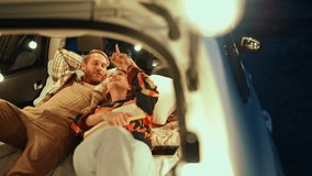 Happy blond young couple looking up and talking in the trunk of the car - Powered by Shutterstock - Get 15% off with code: PIKWIZARD15