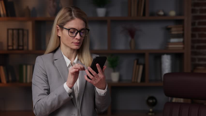 Furious woman looking at cellphone screen, takes off glasses. Woman feeling frustrated of receiving message on email with bad news. Bad electronic device work. | Shutterstock HD Video #1099357157