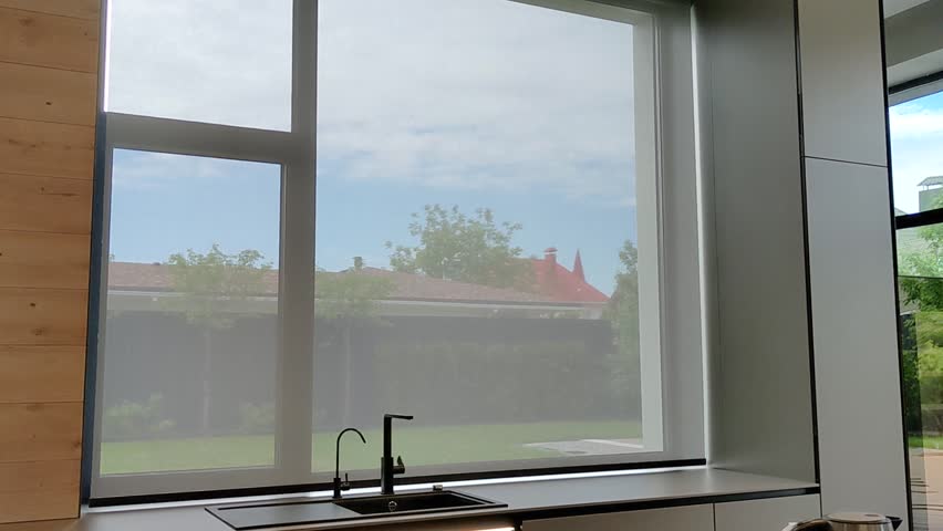 Motorized roller blinds. Automatic solar shades on the window in the kitchen. Screen material for roller blinds. Royalty-Free Stock Footage #1099363383