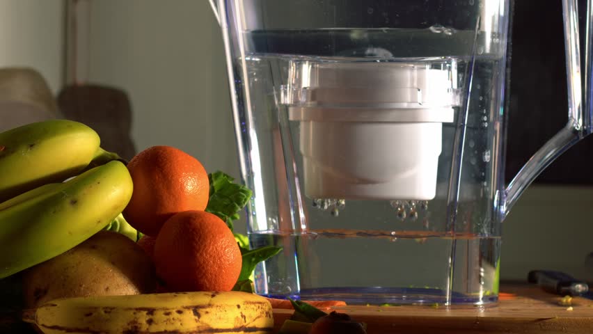 Water filter jug in kitchen with fresh water and fruit medium shot slow motion zoom selective focus | Shutterstock HD Video #1099366245