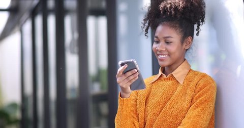 Black woman, smile and phone in social media with headphones in joy for 5G  connection in the outdoors. Happy African American female student smiling  for technology and internet on mobile smartphone