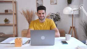 Happy man making video call on laptop at home