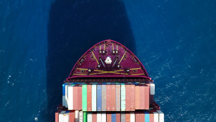 Aerial drone flight over of fully loaded container ship cruising deep blue sea near logistics terminal | Shutterstock HD Video #1099374649