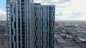 sideways aerial footage of the glass skyscrapers, office buildings and hotels in the city skyline with blue sky and clouds with cars on the street in Nashville Tennessee USA