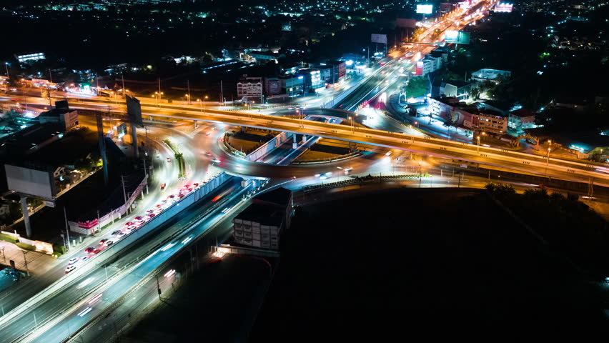 Hyperlapse time-lapse of car traffic transportation above circle roundabout road in urban downtown Asian city at night. Drone aerial view, high angle. Public transport or commuter city life concept | Shutterstock HD Video #1099383119