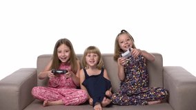 Kids playing video game with joystick sitting on sofa, front view