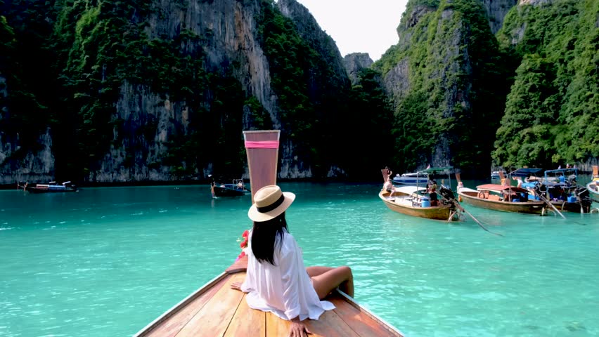 Asian women in front of a longtail boat at Koh Phi Phi Island Thailand, Pileh Lagoon. | Shutterstock HD Video #1099383777