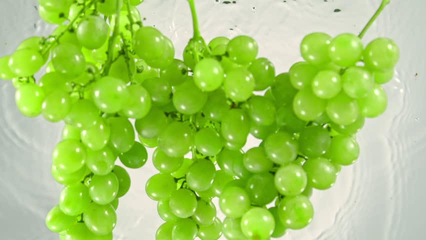 Super Slow Motion Shot of Fresh Green Grape Wine Falling into Water on White Background at 1000 fps. | Shutterstock HD Video #1099389071