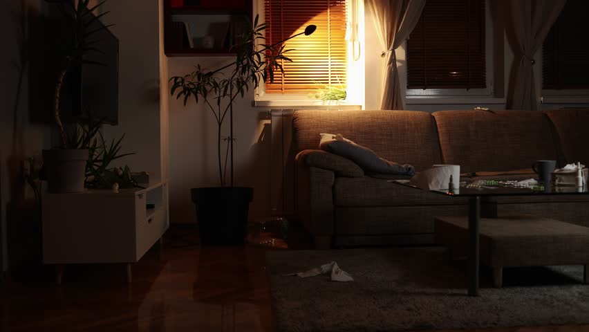 Psychology and mental disorder. Drunk young Caucasian grubby woman sits down on sofa. Dirty living room. Illness girl sitting on couch at evening in home. | Shutterstock HD Video #1099390933