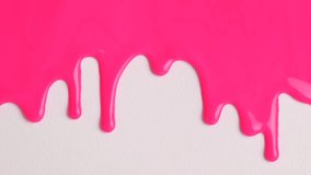 Liquid drops of pink paint color flowing on the white surface. Macro shot of pink paint dripping on the white wall with copy space. Production Close-up. Slow Motion, Abstract art.  - Powered by Shutterstock - Get 15% off with code: PIKWIZARD15