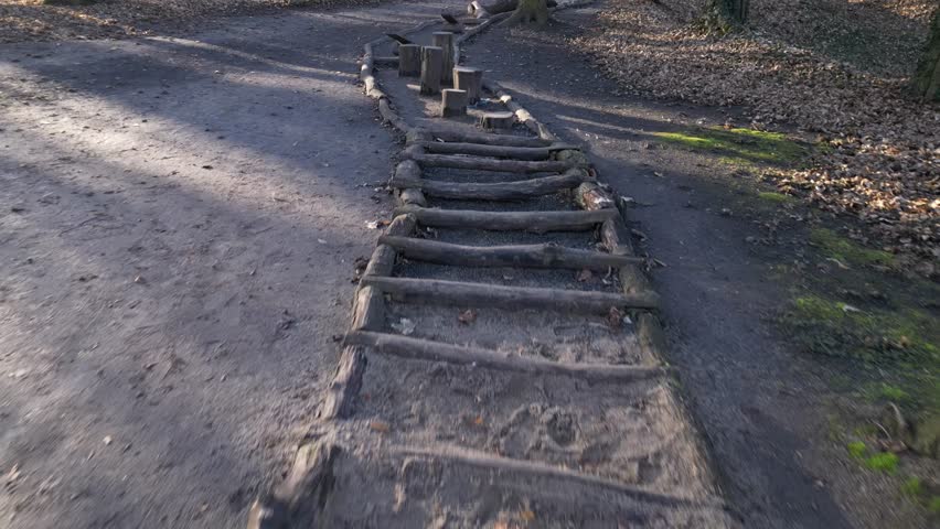 Tactile path for bare feet awakens the senses and uneven endings on the feet alternating different materials wood stone gravel sand bark in a park environment, above, aerial, video, spring, sunny