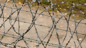 Fence with Sharp Razor Wire Blades. Concertina wire close-up. Pan from left to right. - Powered by Shutterstock - Get 15% off with code: PIKWIZARD15