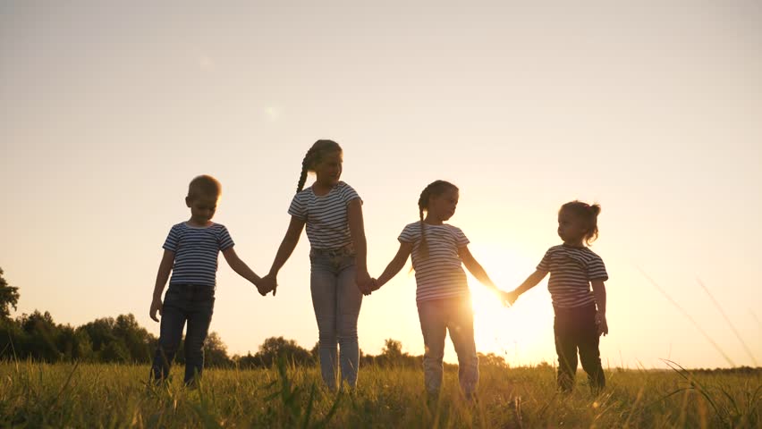 Happy family silhouette in the park. A crowd of children raise their hands up. Family childhood dream concept. The kids raised their hands up. Happy kids teamwork in the park. | Shutterstock HD Video #1099399421