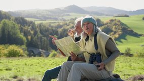 Senior couple having break, looking into paper map during hiking in autumn nature. - Powered by Shutterstock - Get 15% off with code: PIKWIZARD15