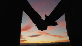 Silhouette of holding hands for a couple against sunset sky - Powered by Shutterstock - Get 15% off with code: PIKWIZARD15