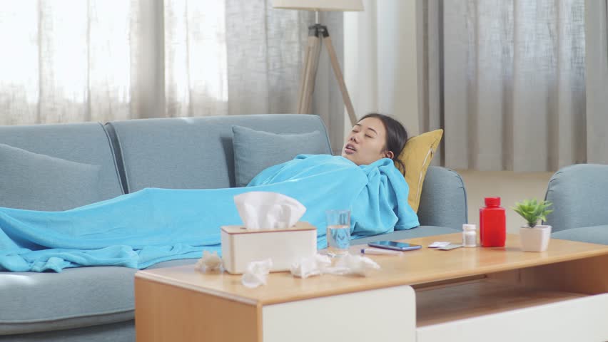 Sick Asian Woman With Blanket Suffering From Cough While Lying On Sofa In The Living Room At Home
 | Shutterstock HD Video #1099402903