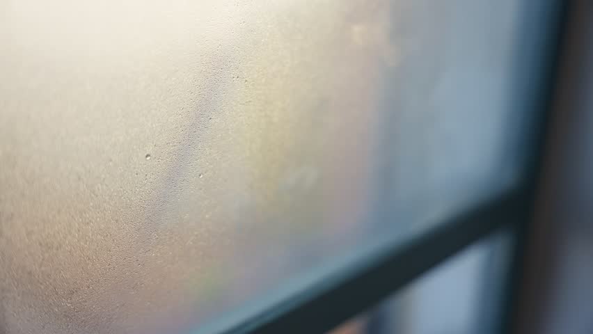 Hand wiping condensation on glass window during cold winter. Warm indoors while cold weather outside. Lonely at home looking out Royalty-Free Stock Footage #1099404067