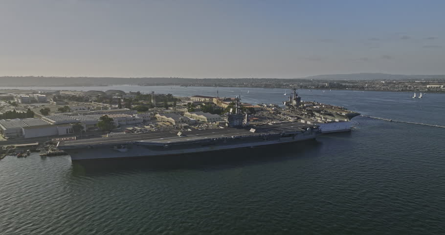 San Diego California Aerial v84 low flyover bay area spotted two us military aircraft carriers on the pierside at naval air base nas north island in coronado - Shot with Mavic 3 Cine - September 2022 Royalty-Free Stock Footage #1099404417