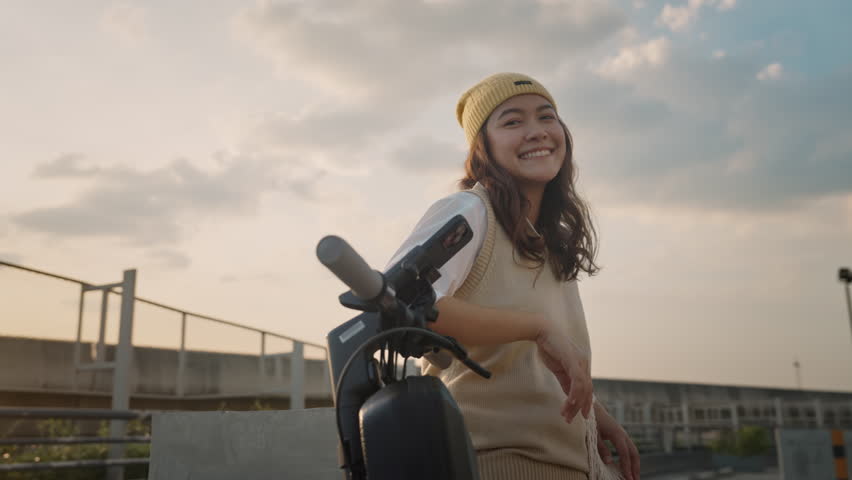 Go green net zero clean low energy eco ride push motor e-scooter. Asia people young woman Gen Z girl happy travel urban city life sun light by modern public metro rail train relax smile look at camera | Shutterstock HD Video #1099407989