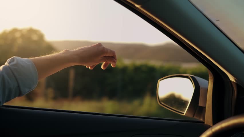 View from car window on road and hand man gestures to beat of music