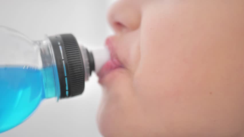boy teenager drinks drinking water from a bottle, slow motion
