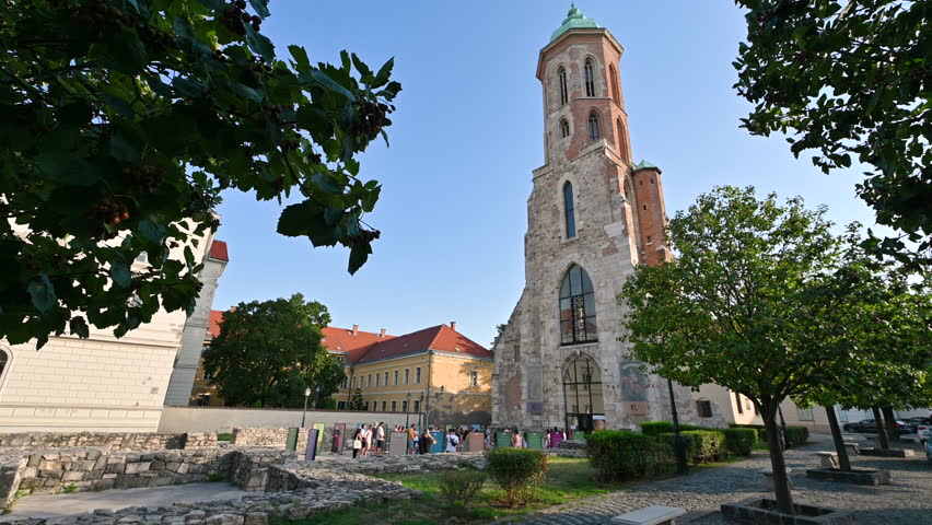 Budapest,Hungary,August 2022. On the city hill the Church of St. Mary Magdalene. A group of tourists stopped in front to observe her. Beautiful summer day.