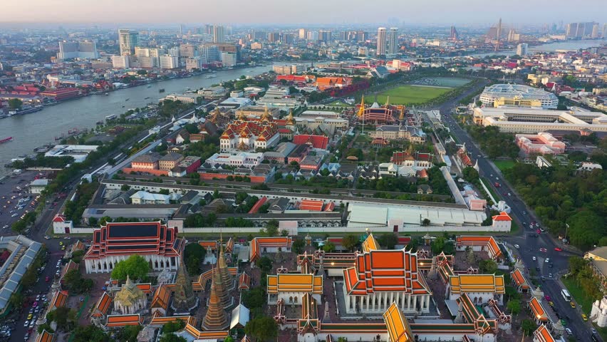 Aerial view Day to Night of Chao Phraya River with Royal Grand Palace and Emerald Buddha Temple Landmark of Bangkok, Thailand. Amazing Drone Footage over the City skyline in twilight.