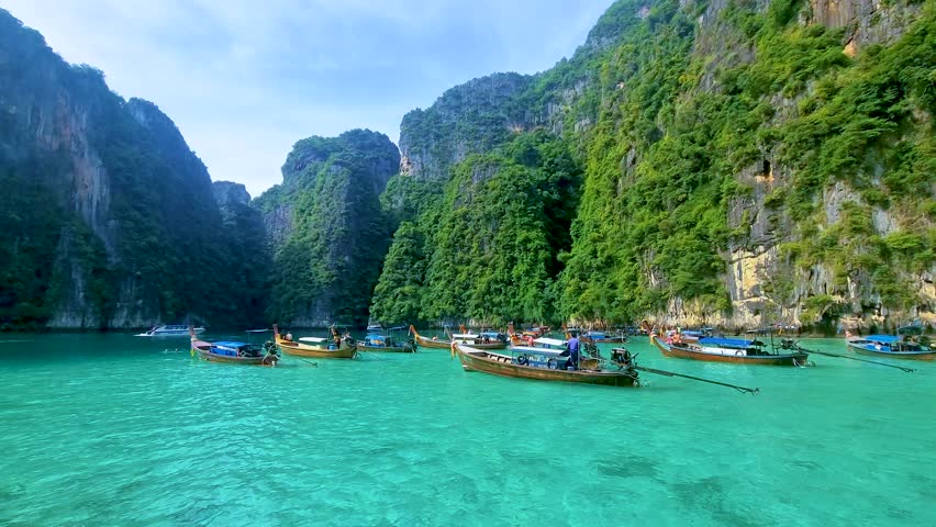 View of the turqouse colored ocean with longtail boats at Koh Phi Phi Don Thailand.  | Shutterstock HD Video #1099429445