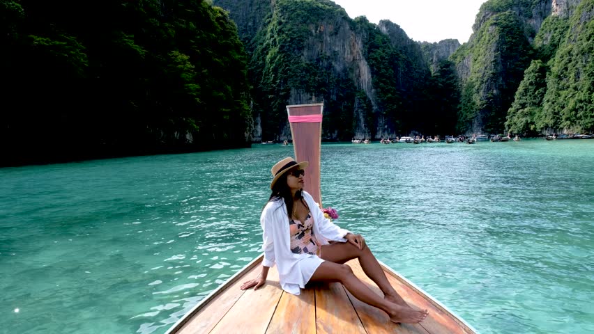 Asian women in front of a longtail boat at Koh Phi Phi Island Thailand, Pileh Lagoon. | Shutterstock HD Video #1099429461