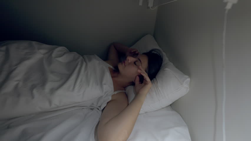 Woman turns light in the middle of the night unable to sleep. Person suffering from insomnia and stress feeling sleepless | Shutterstock HD Video #1099431603