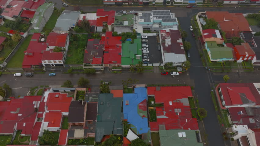 High angle view of low houses in residential urban borough. Aerial view of town with lot of greenery, trees and parks. San Jose, Costa Rica