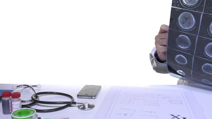 Doctor in office lookin brain x-ray scan and writes prescription