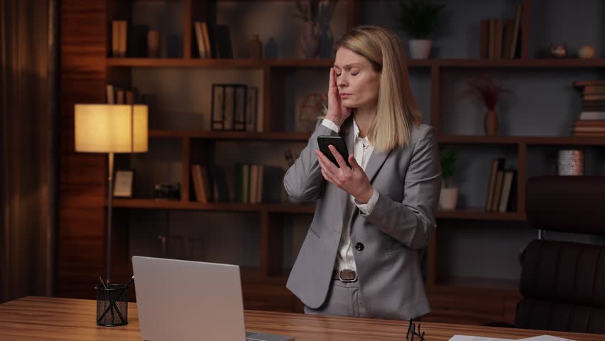 Shocked business woman looking in mobile phone, dissatisfied with bad news message, she upset problems, refusal financial notification mistake, bank debt, write-off of interest on the loan. | Shutterstock HD Video #1099448377