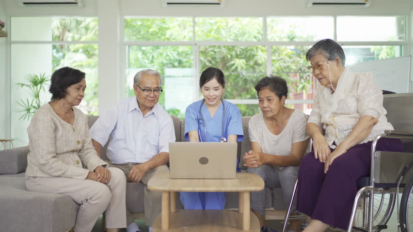 An Asian nurse talking to a group of old elderly patient or pensioner people smiling, relaxing, having fun together in nursing home. Senior lifestyle activity recreation. Retirement. Health care | Shutterstock HD Video #1099448641