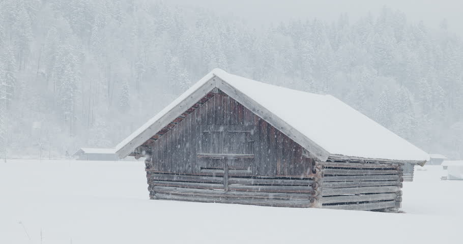 Garmisch, Bavaria, Germany - 21 January, 2023: Alpine farmers shed under heavy snowfall