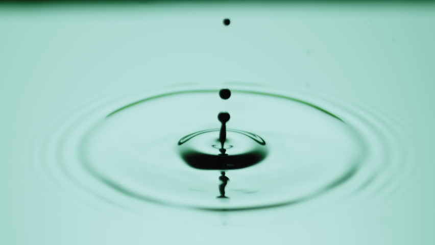 Macro crane shot of black drop drips on green opaque liquid with light reflection splashing and creating concentric circles on it | Face cosmetics commercial | Shutterstock HD Video #1099451641