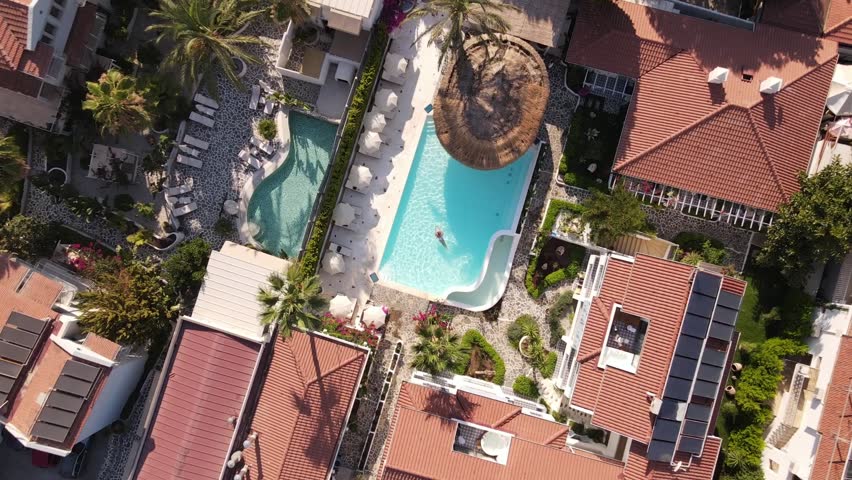 Aerial view of woman swimming in hotel pool, summer time. | Shutterstock HD Video #1099456169