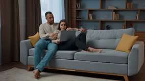 Ethnic multiracial family husband wife cuddle on cozy sofa shopping online at home use laptop computer watch film together adult couple african american man caucasian woman browsing internet website - Powered by Shutterstock - Get 15% off with code: PIKWIZARD15