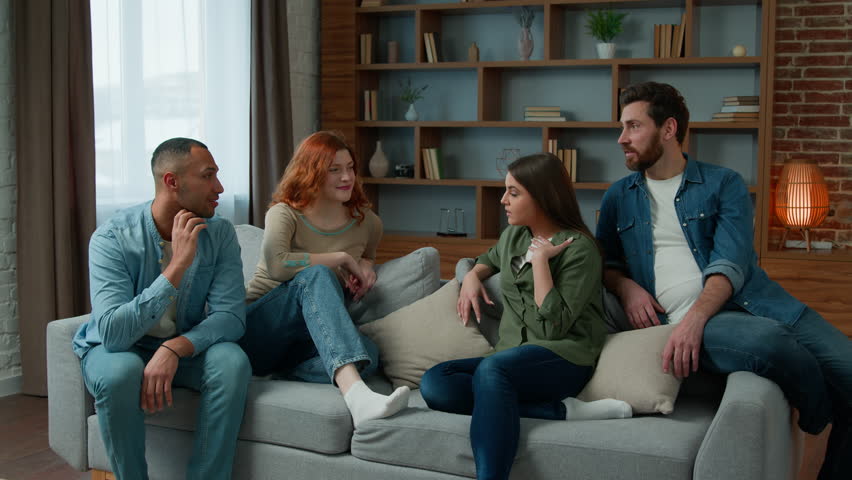 Group of diverse ethnic multiracial friends girls guys sit on sofa at home talking argue conflict friendly dispute debate discussing problem ambitious expressive men women arguing discussion indoors Royalty-Free Stock Footage #1099456517