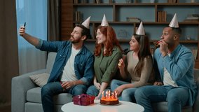 Happy multi ethnic friends diverse men women african american caucasian hispanic people in party hats make selfie photo funny video on mobile phone hold birthday cake celebrate event virtual meeting
