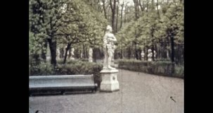 Green garden with marble women sculptures in summer city. 1980s Petersburg, Russia. Beautiful park with ancient monuments, landmark. Old archives. Vintage, archival color film. Retro, historic archive