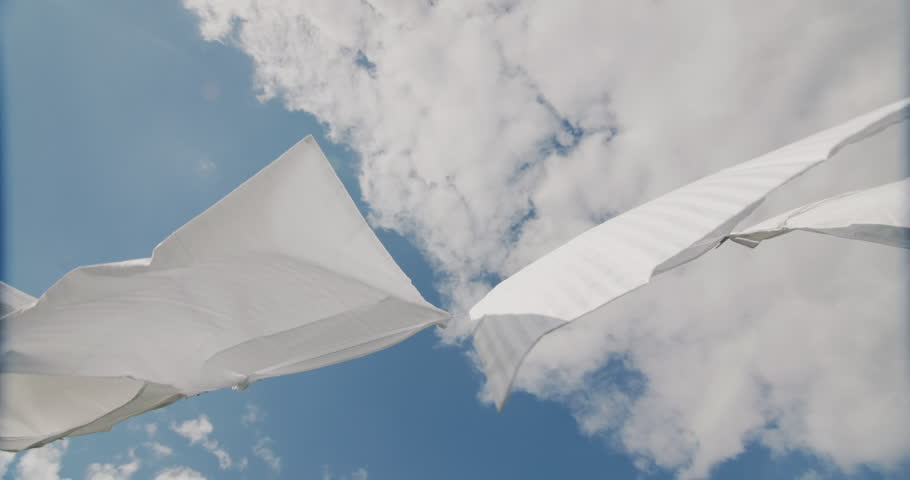 White bedding drying against a blue sky. Low angle view Royalty-Free Stock Footage #1099462863